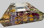 A rectangle clear resin box filled with dried flowers, botanical elements, and a small central clear insert for 5x7 