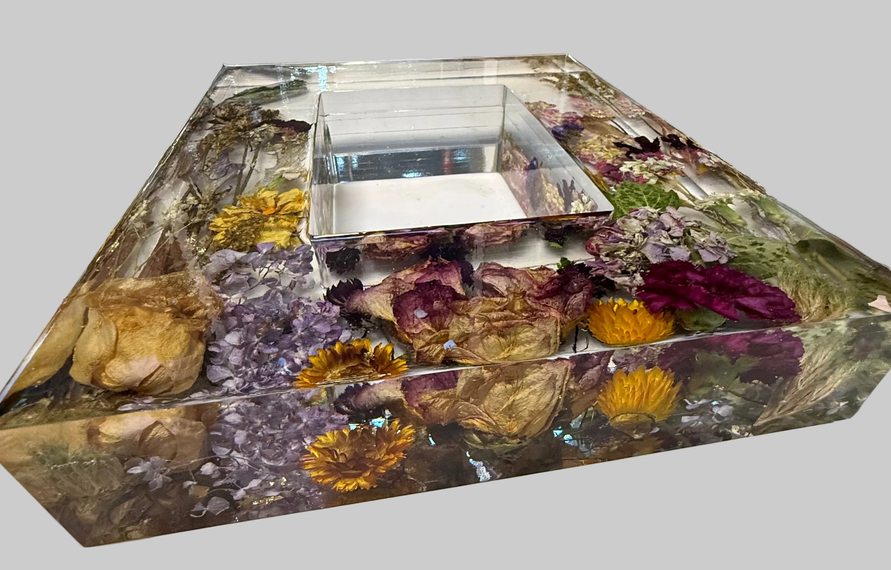 A rectangle clear resin box filled with dried flowers, botanical elements, and a small central clear insert for 5x7 